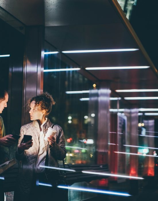 Office worker man shows woman colleague information on smartphone and discusses project